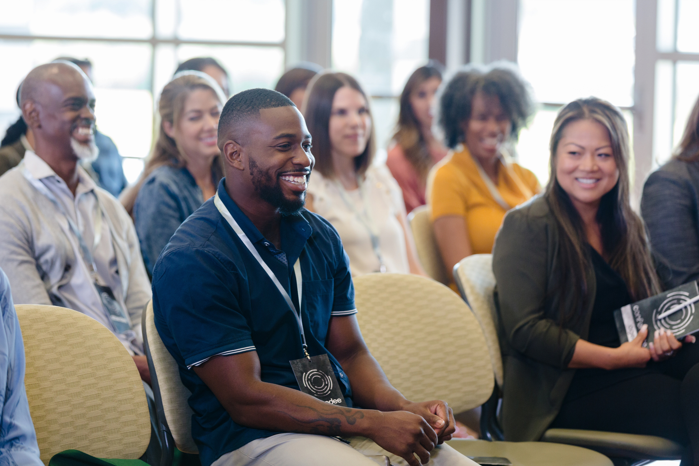 Diverse conference attendees enjoy session speaker